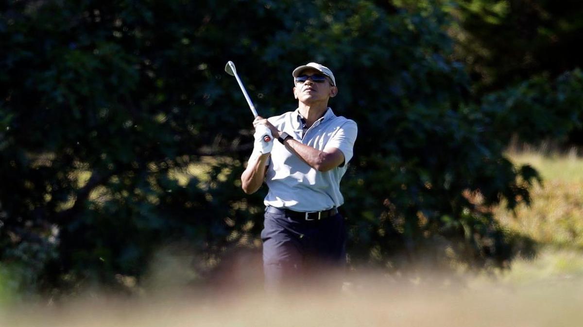 
President Barack Obama watches the flight of his ball while golfing Wednesday, Aug. 12, 2015, at Martha's Vineyard. The president, first lady Michelle Obama and daughter Sasha are vacationing on the island.
