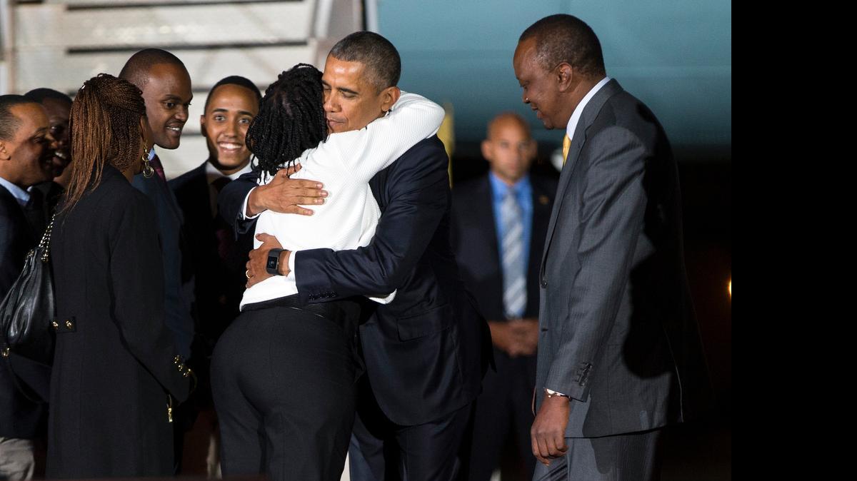
Kenyan President Uhuru Kenyatta, right, watches as President Barack Obama, center, hugs his half-sister, Auma Obama, after he arrived at Kenyatta International Airport, on Friday, July 24, 2015, in Nairobi, Kenya. Obama is traveling on a two-nation African tour where he will become the the first sitting U.S. president to visit Kenya and Ethiopia. 
