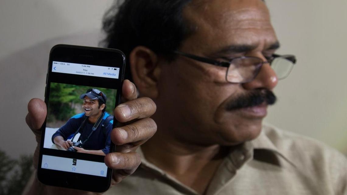 A man shows a picture of Alok Madasani, an engineer who was injured in the shooting Wednesday night in a crowded suburban Kansas City bar, on a mobile phone as Madasani's father Jaganmohan Reddy talks to the media at his residence in Hyderabad, India, Friday, Feb. 24, 2017.