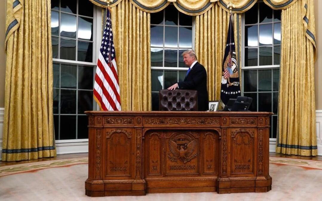 President Donald Trump and the Resolute desk in the Oval Office, Wednesday, Feb. 1, 2017.