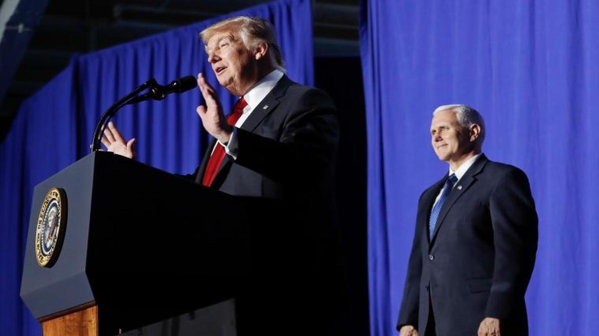 President Donald Trump, accompanied by Vice President Mike Pence, center, and Homeland Security Secretary John F. Kelly, speaks at the Homeland Security Department in Washington, Wednesday, Jan. 25, 2017.