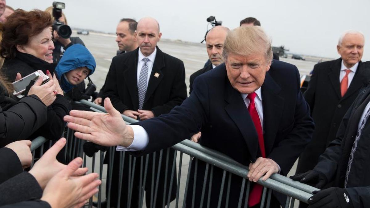 President Donald Trump shakes hands with supporters after arriving at Salt Lake City International Airport, Monday, Dec. 4, 2017, in Salt Lake City.