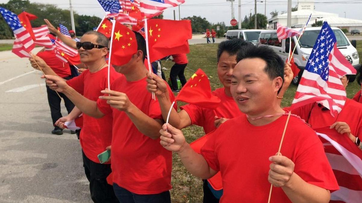 Supporters of Chinese President Xi Jinping line the street outside Palm Beach International Airport on Thursday.