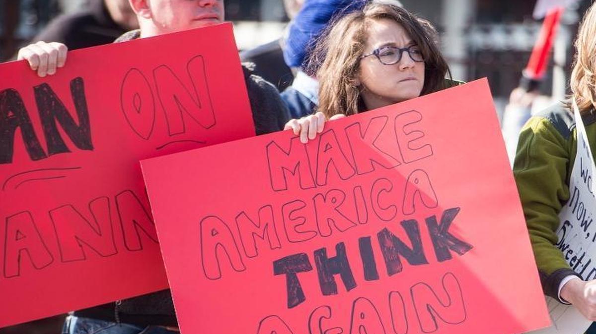 Maria Almanza holds a "Make America Think Again" sign during a protest on Sunday, Feb. 5, 2017 in Lynchburg, Virginia.