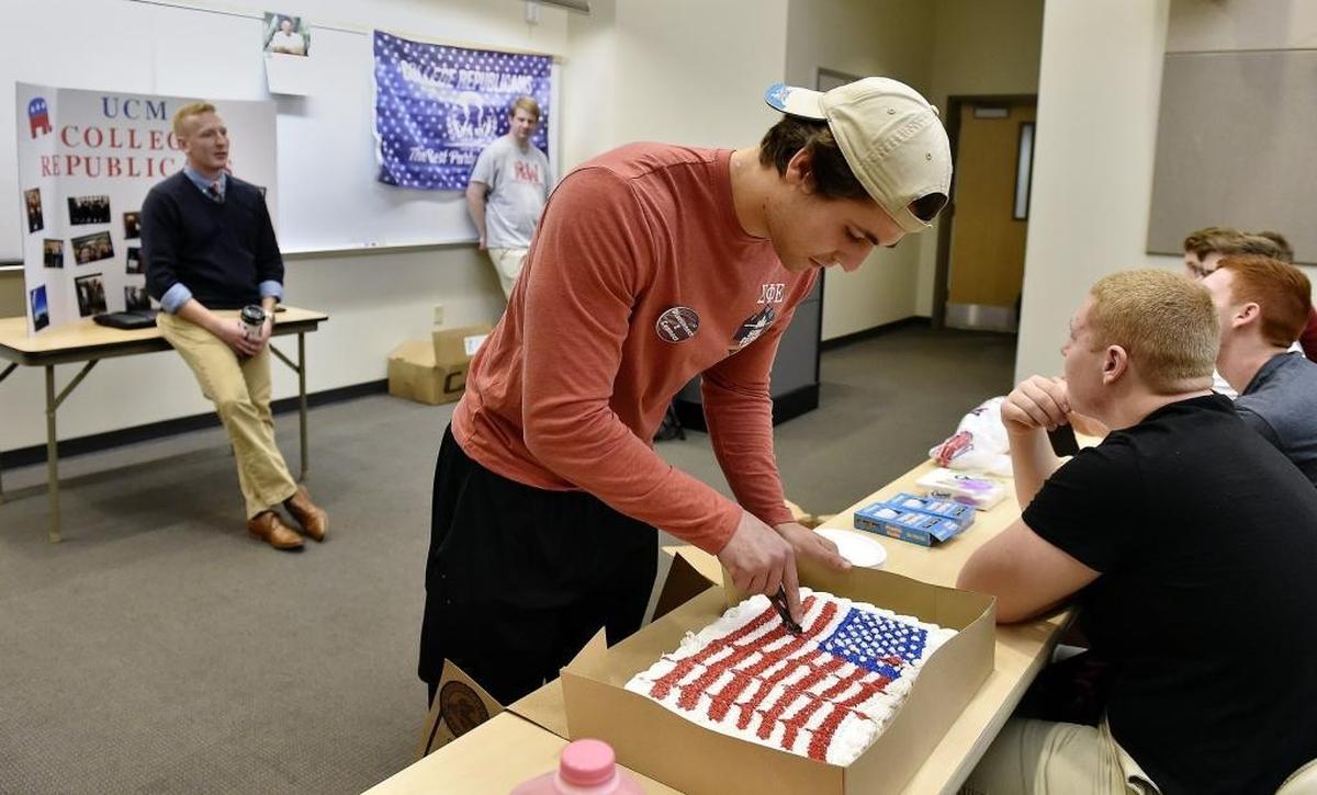 At a meeting of University of Central Missouri College Republicans Tuesday, Nov. 15, 2016, the group celebrated they GOP sweep of the presidency, congress and statewide offices. Jacob Hettzel, club vice president, cuts the cake as Jacob Davis, president, talks with members. These millennial Republicans say they don't necessarily agree with the entire Republican platform, but support the party and are politically active.