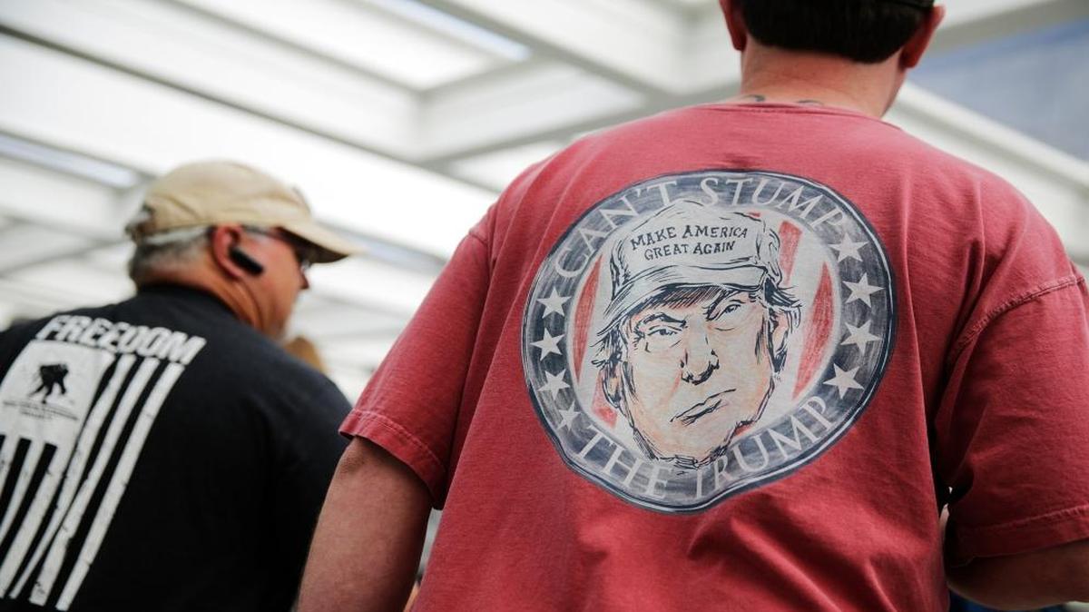 A caricature of President Donald Trump decorates the shirt of a convention-goer as he walks into the NRA annual convention in Atlanta.