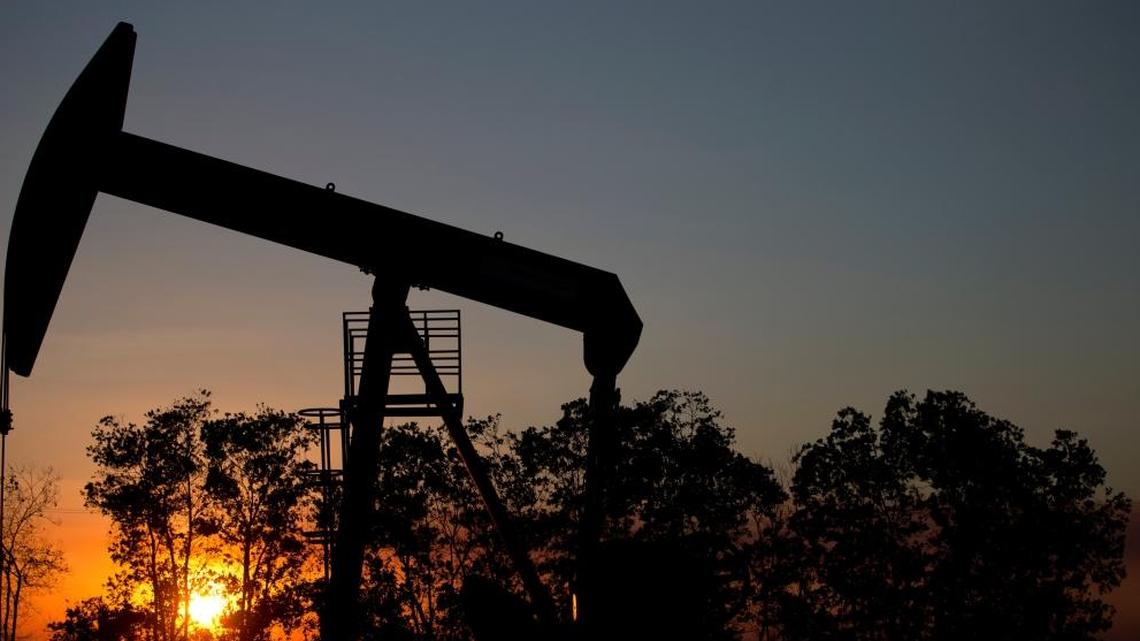 In this Feb. 19, 2015 photo, the sun sets behind an oil well in a field near El Tigre, a town within Venezuela's Hugo Chavez oil belt, formally known as the Orinoco Belt. President Nicolas Maduro, whose approval rating has plunged to around 25 percent, has no choice but to lean on state-fun oil company PDVSA to help Venezuela back on its feet and has been quietly trying to lure back foreign drillers.