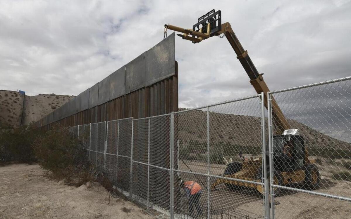 Workers raising a taller fence along the border separating the towns of Anapra, Mexico, and Sunland Park, New Mexico.