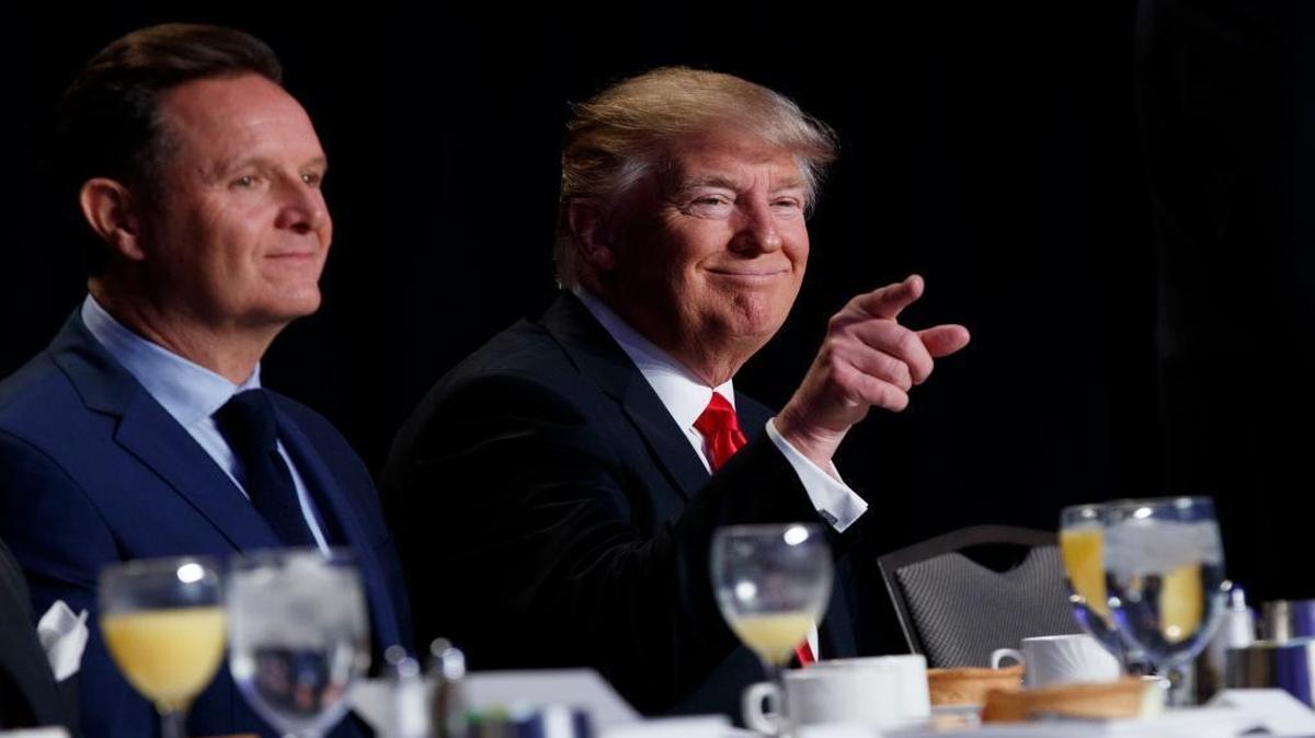 President Donald Trump, accompanied by television producer Mark Burnett, points to the crowd during the National Prayer Breakfast, Thursday, Feb. 2, 2017, in Washington.