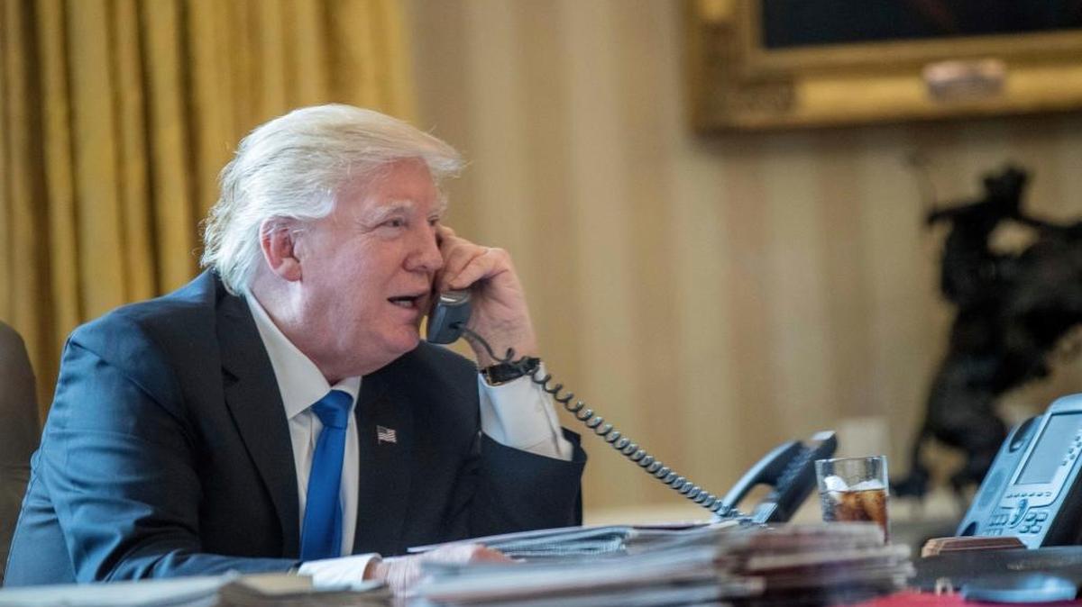 President Donald Trump speaks on the phone with Russian President Vladimir Putin, Saturday, Jan. 28, 2017, in the Oval Office at the White House in Washington.