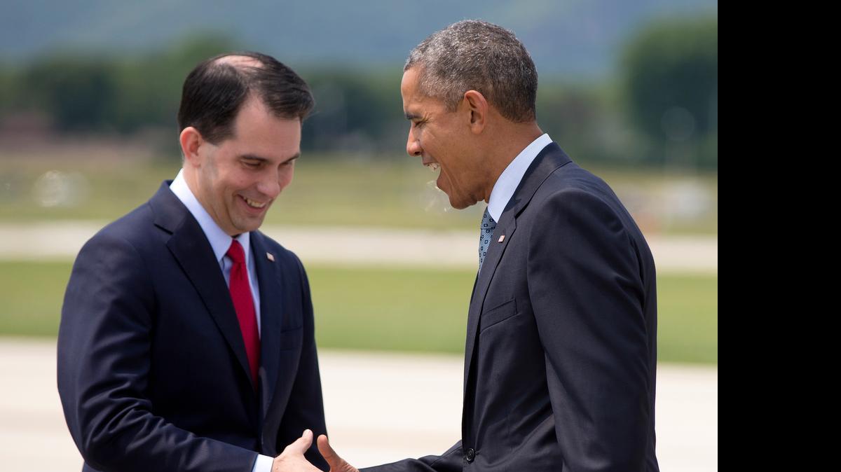 
President Barack Obama is greeted by Wisconsin Gov. Scott Walker as he arrives on Air Force One at La Crosse Regional Airport, Thursday, July 2, 2015, in La Crosse, Wis. The president was en route to the University of Wisconsin at La Crosse where he spoke about the economy and promoted a proposed Labor Department rule that would make more workers eligible for overtime. 
