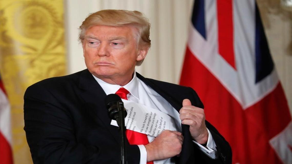 President Donald Trump tucks away his notes near the conclusion of a news conference with British Prime Minister Theresa May on Jan. 27, 2017.