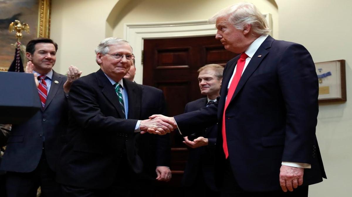 President Donald Trump shakes hands with Senate Majority Leader Mitch McConnell, R-Ky., during a ceremony where he was to sign H.J. Res. 38 in the Roosevelt Room of the White House in Washington, Feb. 16, 2017. Behind from left are Reps. Evan Jenkins, R-W.Va., and Jim Jordan, R-Ohio.
