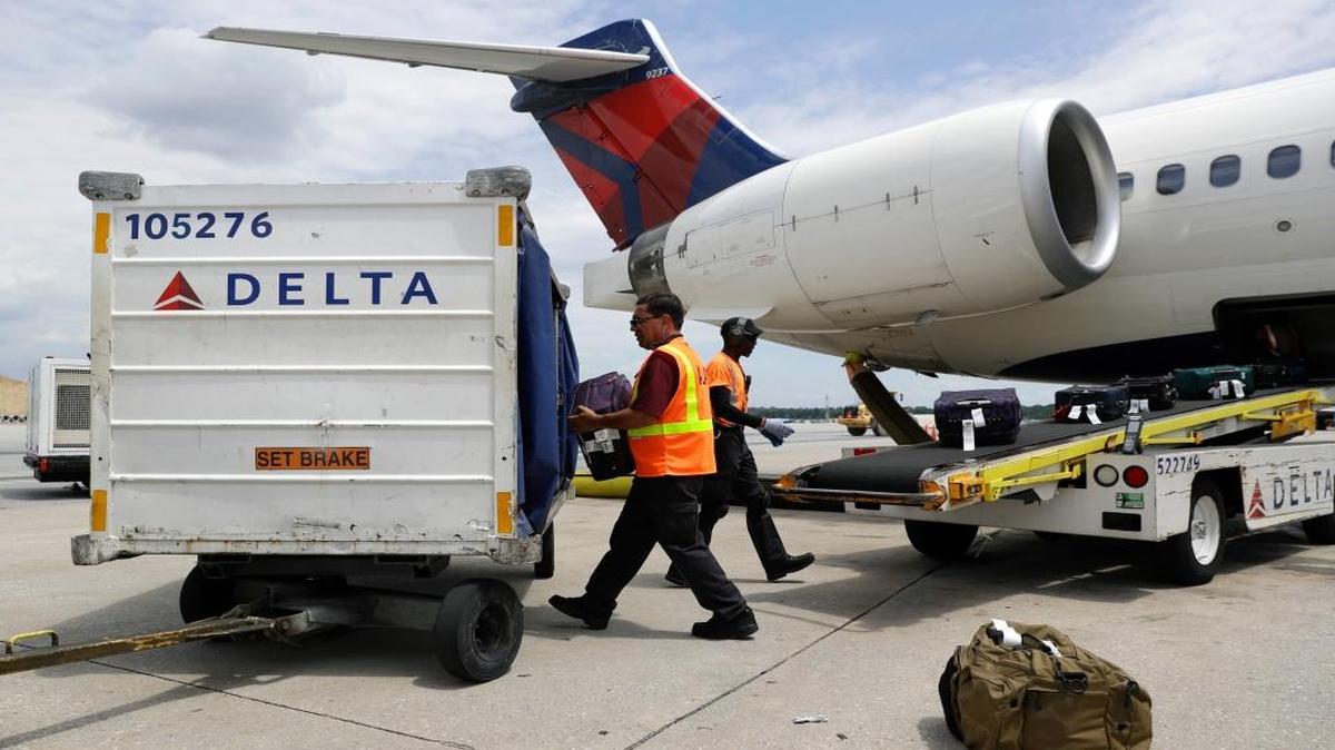 In this July 12, 2016, file photo, workers unload baggage from a Delta Air Lines flight at Baltimore-Washington International Thurgood Marshall Airport in Linthicum, Md.