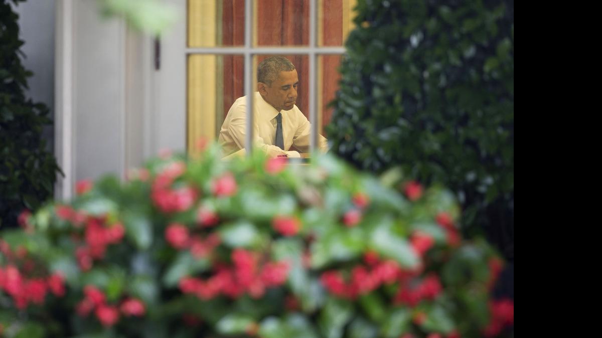 
President Barack Obama is seen working in the Oval Office of the White House in Washington, Friday, June 26, 2015, before speaking in the Rose Garden after the Supreme Court declared that same-sex couples have the right to marry anywhere in the US. 
