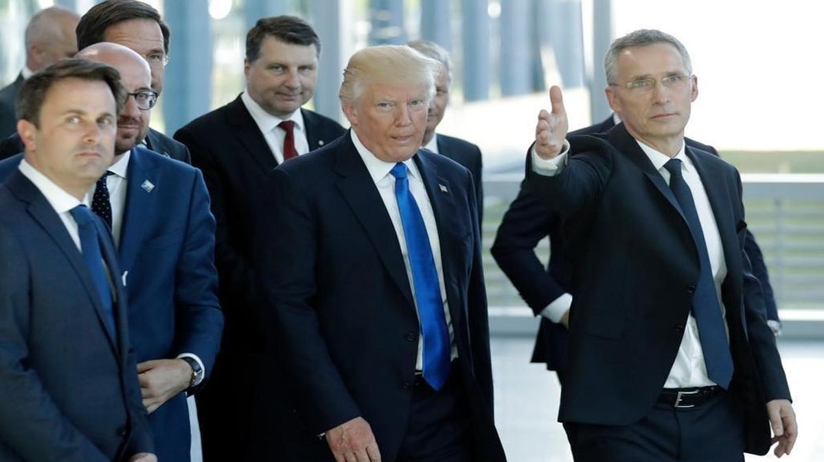 President Donald Trump, center, speaks with NATO Secretary-General Jens Stoltenberg, right, during a NATO summit of heads of state and government in Brussels.