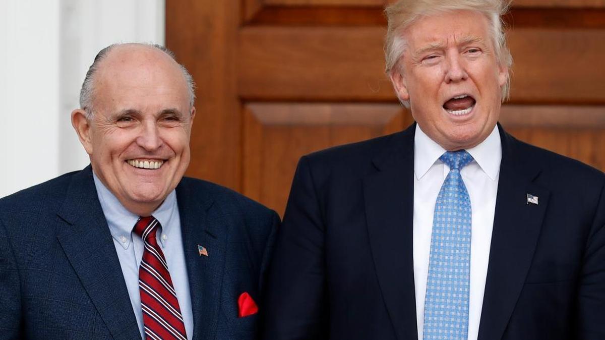President-elect Donald Trump calls out to media as he and former New York Mayor Rudy Giuliani pose for photographs as Giuliani arrives at the Trump National Golf Club Bedminster clubhouse, Sunday, Nov. 20, 2016, in Bedminster, N.J.