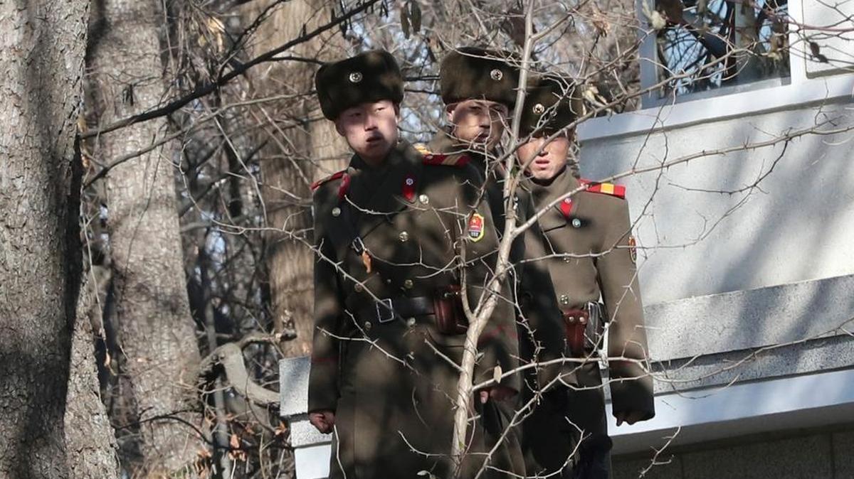 Three North Korean soldiers look at the South side near the spot where a North Korean soldier crossed the border on Nov. 13, at the Panmunjom in the Demilitarized Zone, South Korea.