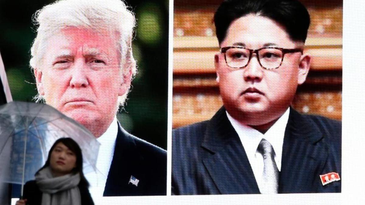 A woman walks by a huge screen showing U.S. President Donald Trump, left, and North Korea's leader Kim Jong Un, in Tokyo, Friday, March 9, 2018. After a year of threats and diatribes, U.S. President Donald Trump and third-generation North Korean dictator Kim Jong Un have agreed to meet face-to-face for talks about the North’s nuclear program.