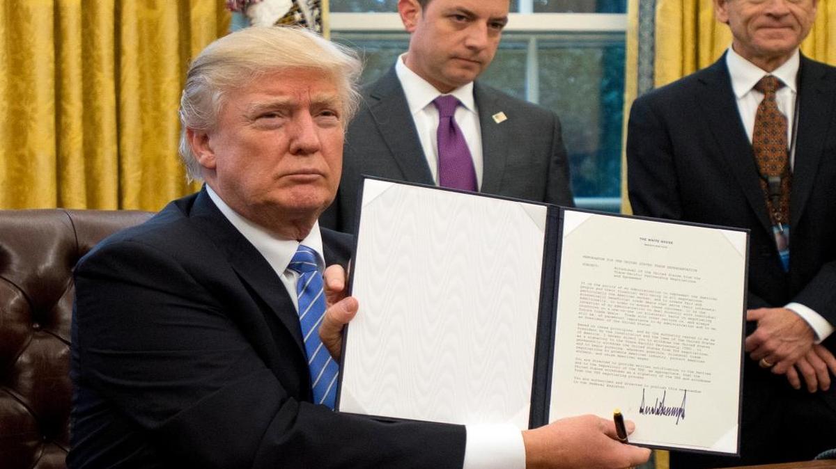 President Donald Trump shows the Executive Order withdrawing the US from the Trans-Pacific Partnership (TPP) after signing it Monday, January 23, 2017.
