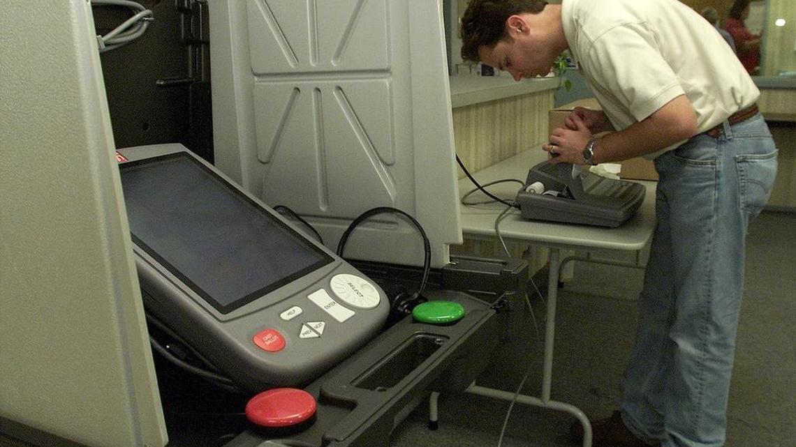In a 2000 file photo, a Hart InterCivic manager installs the first eSlate machines. They essentially haven’t changed.