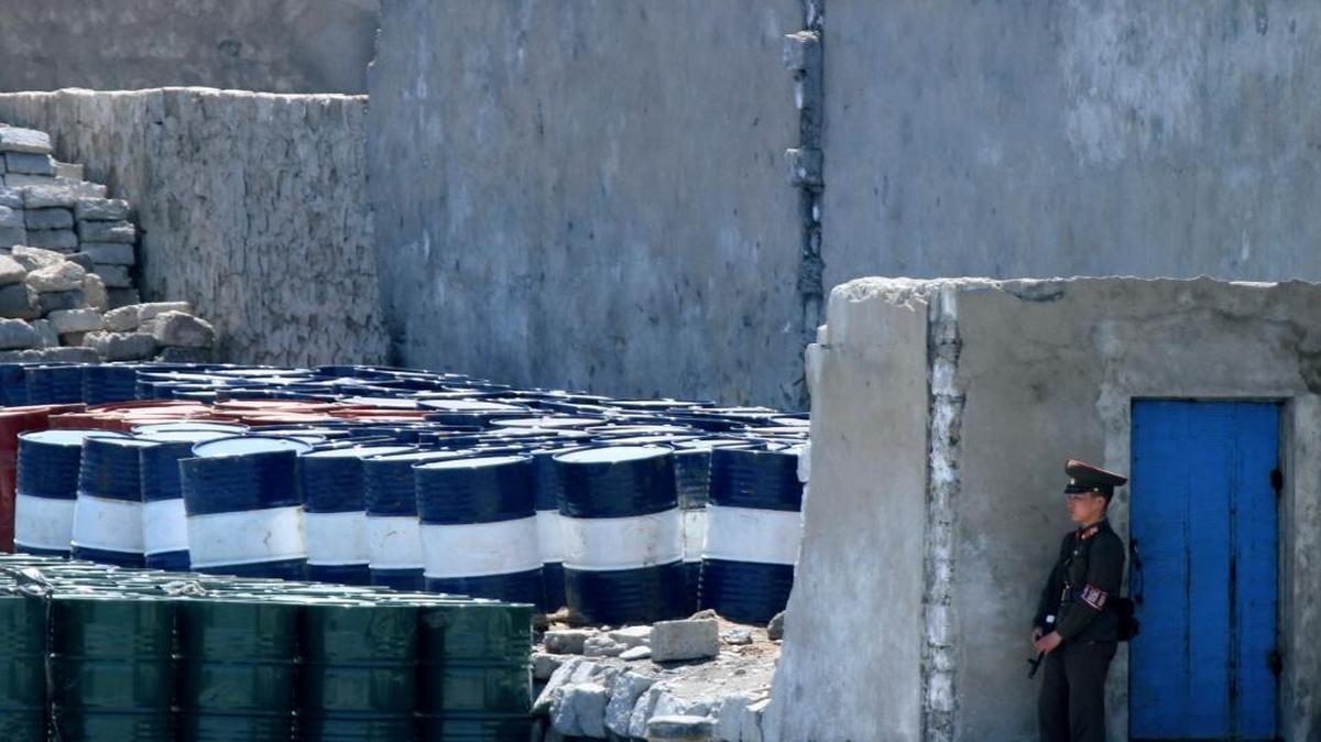 A North Korean soldier stands guard near oil barrels stocked up near the river bank of the North Korean town of Sinuiju, opposite the Chinese border city of Dandong. Chinese Vice Commerce Minister Qian Keming said on Monday the issue of China-U.S. trade should be kept separate from the issue of North Korean security threats, pushing back on statements from U.S. President Donald Trump.