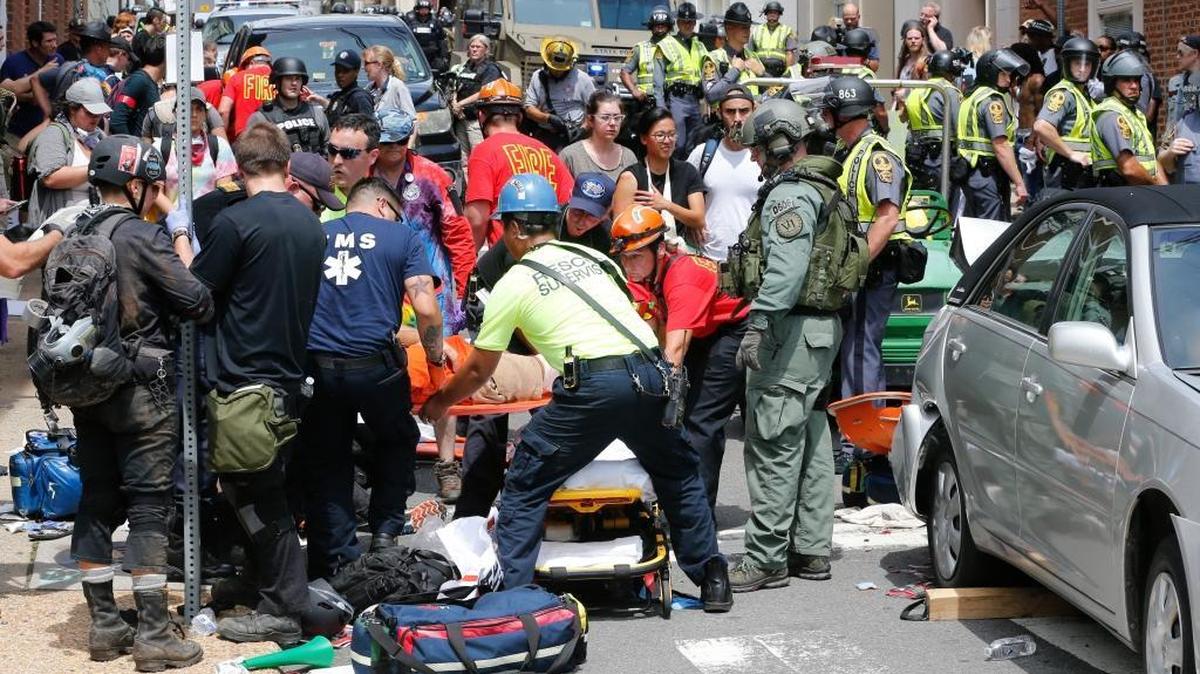 Rescue personnel help injured people after a car ran into a large group of protesters after an white nationalist rally in Charlottesville, Va., Saturday. The nationalists were holding the rally to protest plans by the city of Charlottesville to remove a statue of Confederate Gen. Robert E. Lee. There were several hundred protesters marching in a long line when the car drove into a group of them.