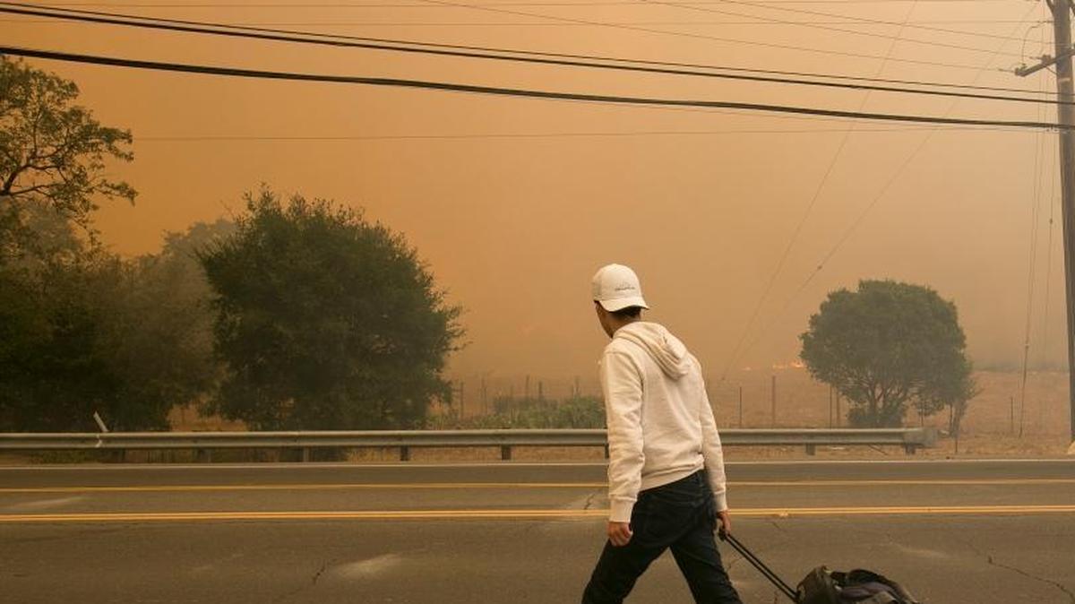 An area resident evacuates his Silverado Trail home as flames from a wildfire approach Monday, Oct. 9, 2017, in Napa, Calif.