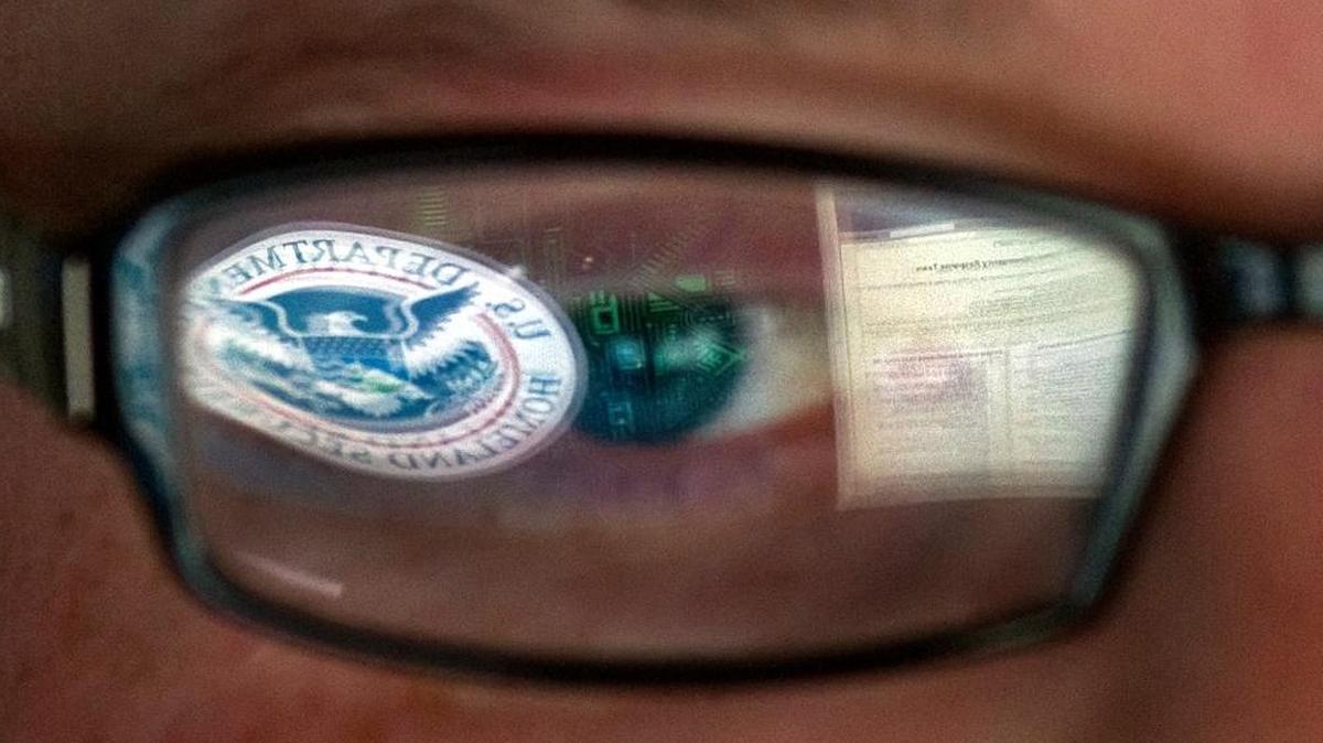 FILE - This Sept. 30, 2011 file photo shows a reflection of the Department of Homeland Security logo in the eyeglasses of a cybersecurity analyst at the watch and warning center of the Department of Homeland Security's secretive cyber defense facility in Idaho Falls, Idaho. The center is tasked with protecting the nation’s power, water and chemical plants, electrical grid and other facilities from cyber attacks.