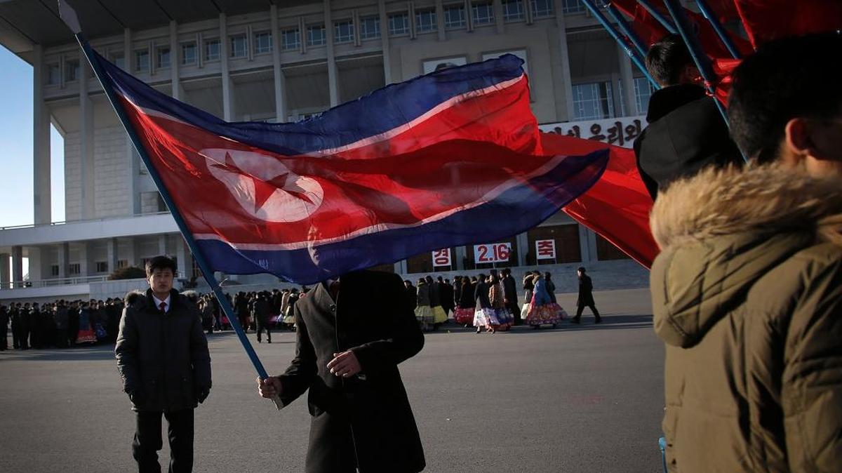 A North Korean man carries his country's national flag after celebrations of the "Day of the Shining Star" or birthday anniversary of late North Korean leader Kim Jong Il in Pyongyang, North Korea.