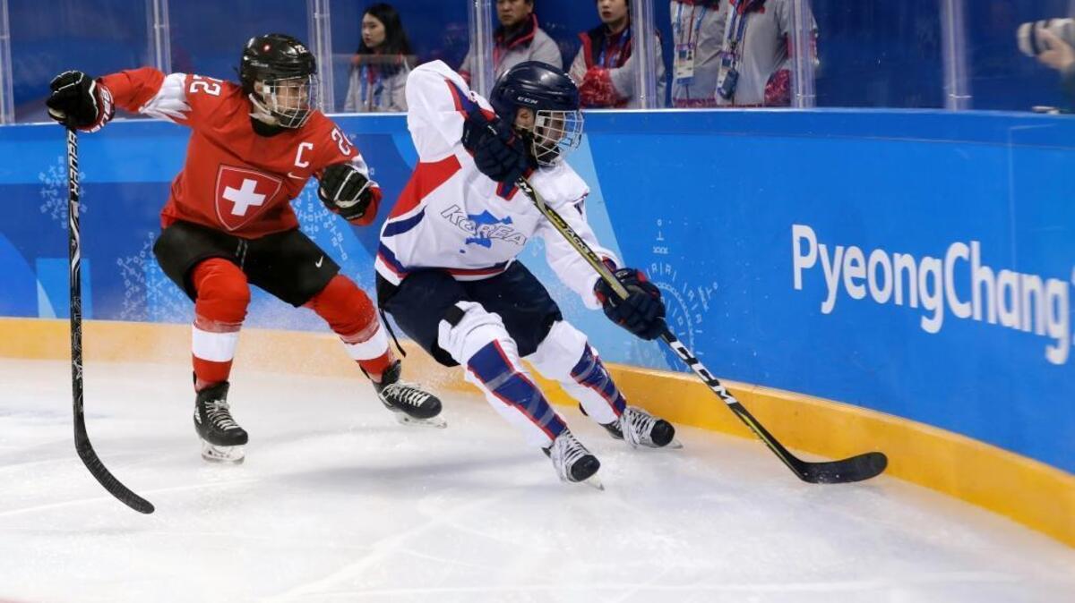 Livia Altmann, of Switzerland, and South Korea's Randi Heesoo Griffin, of the combined Koreas team, battle for the puck during the first period of the preliminary round of the women's hockey game at the 2018 Winter Olympics in Gangneung, South Korea.